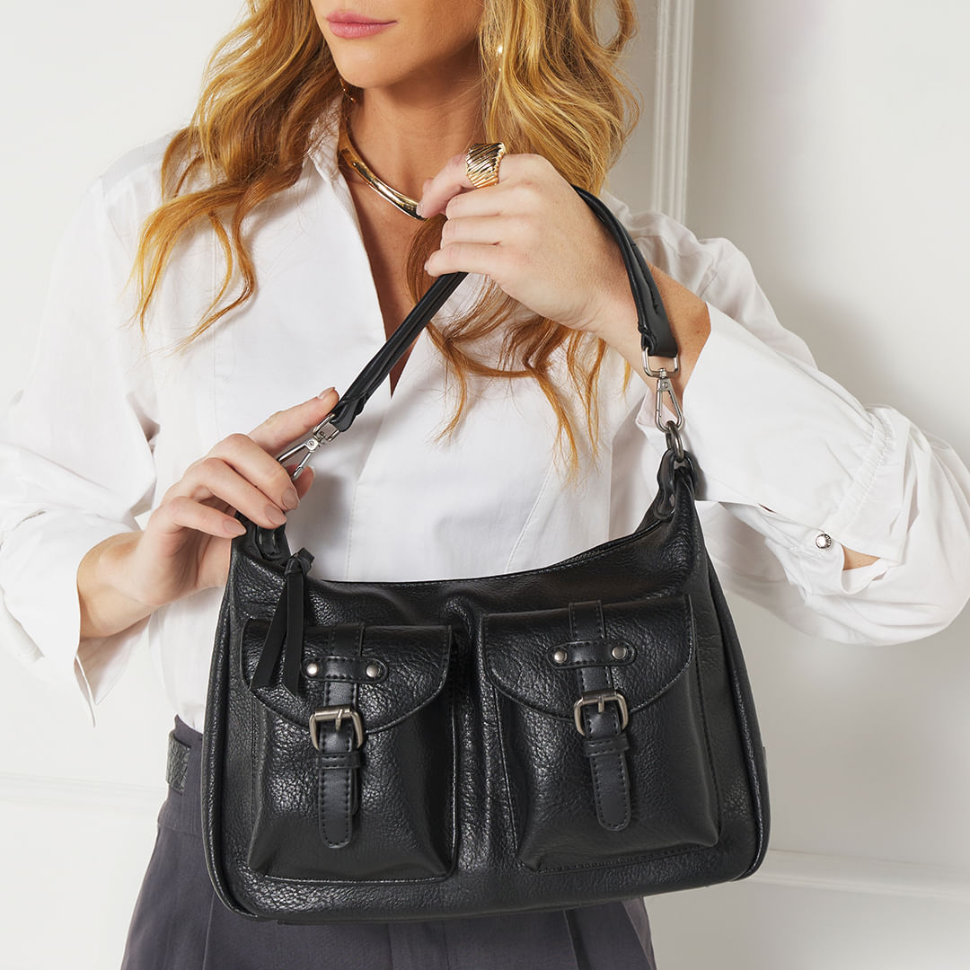 Bolsa WJ preta sendo segurada por modelo mostrando proporção e alça transversal